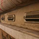 E� arrivato il momento di uscire: scendiamo le scale e ci immettiamo su via Nicolai. Qui, all'estremit� del portico d'ingresso e al cospetto del via vai continuo di gente, ci accorgiamo dell'esistenza di vecchie buche per le lettere in pietra bianca a lungo occultate ma riportate alla luce in seguito ai lavori di restauro